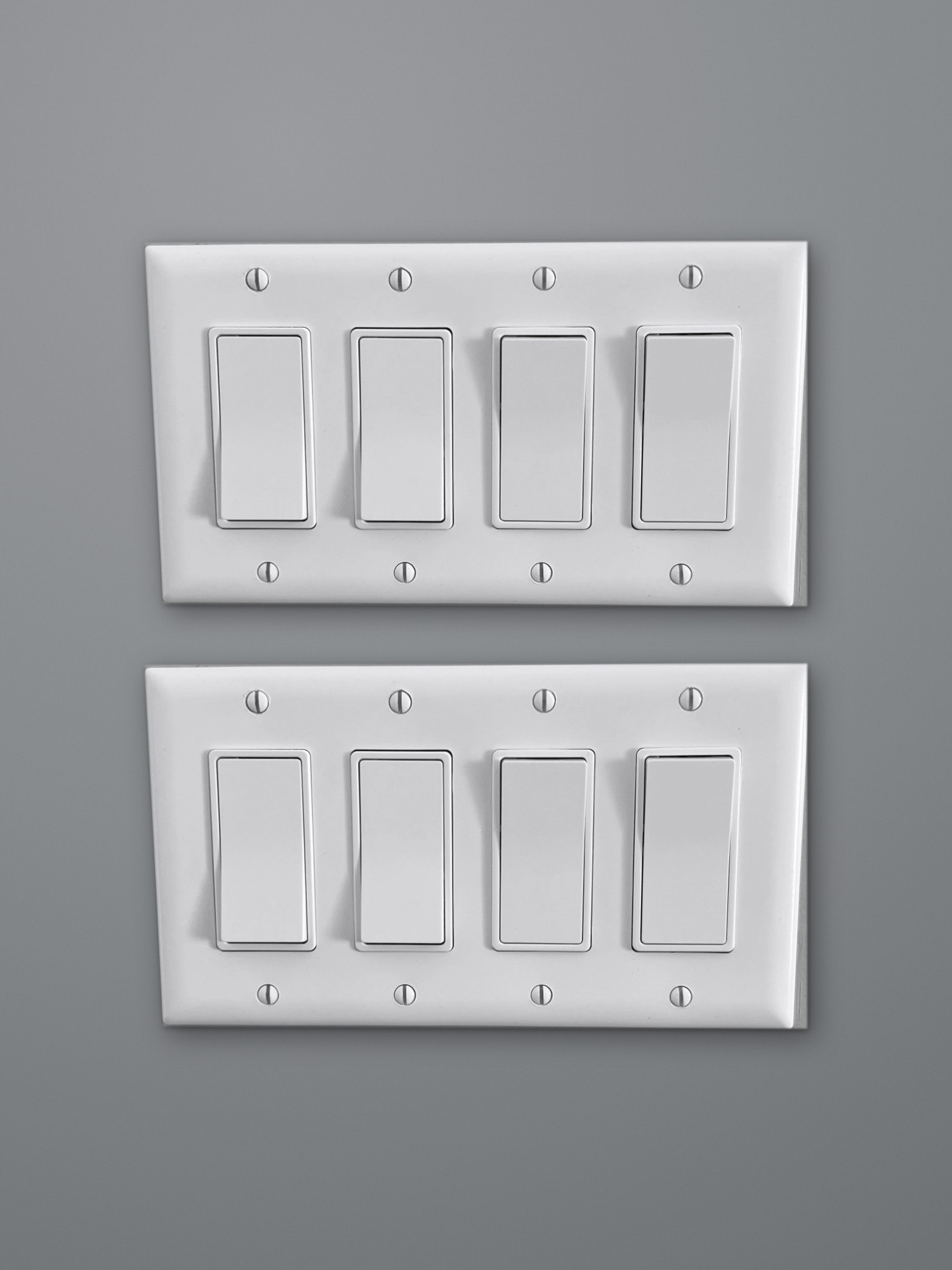 Two white four-gang wall plates stacked on a grey wall, eight rocker switches in all